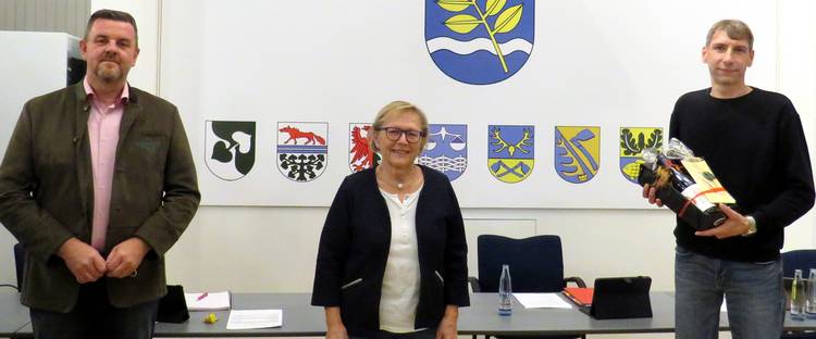 Foto (© Gemeinde Lehre): Ortsbürgermeisterin Edelgard Hahn (Mitte) und Gemeindebürgermeister Andreas Busch (links) verabschieden Josua Mikalo.
