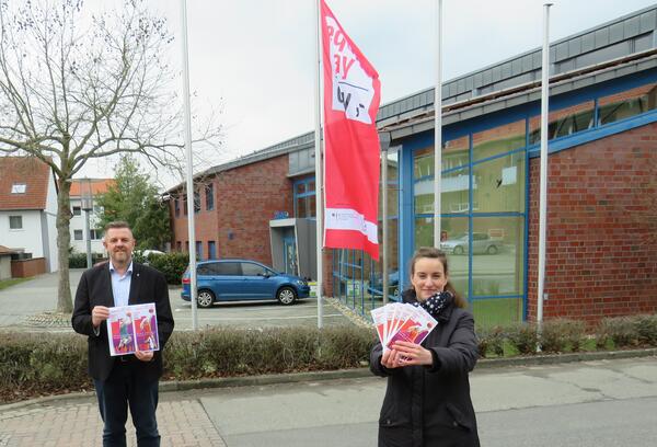 Bild vergr&ouml;&szlig;ern: Foto (Gemeinde Lehre): Bürgermeister Andreas Busch und Gleichstellungsbeauftragte Julia Carluccio vor der "Equal-Pay-Day"-Flagge am Rathaus.