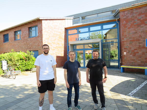 Bild vergr&ouml;&szlig;ern: Foto (© Gemeinde Lehre): Chris Schulze (Mitte) gratuliert Fachinformatiker Leon Frank (l.) zur bestandenen Ausbildung und heißt Michael Mraczny (r.) im Team willkommen.