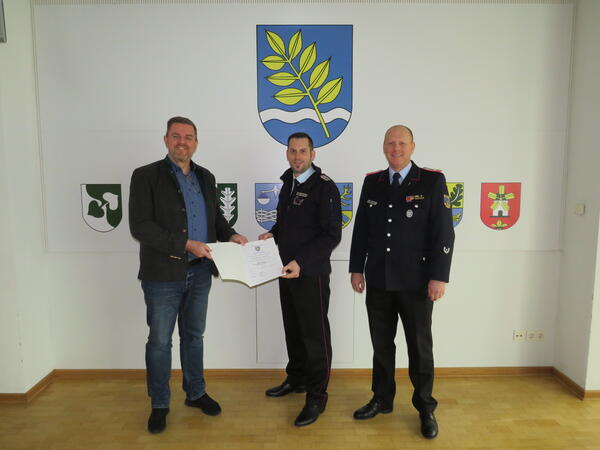 Bild vergr&ouml;&szlig;ern: Foto (© Gemeinde Lehre): Gemeindebürgermeister Andreas Busch und Gemeindebrandmeister Simon Rebel gratulieren Jan Wehrstedt.