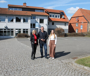 Bild vergr&ouml;&szlig;ern: Claudia Kayser und Lara Höthke von der Volksbank und Bürgermeister Andreas Busch stehen auf dem Parklplatz hinter dem Gebäude der Volksbank in Lehre.