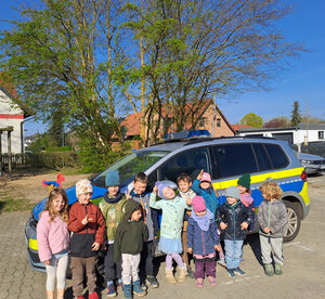 Bild vergr&ouml;&szlig;ern: Die Kinder der Roten Gruppe stehen zusammen vor dem Polizeiauto.