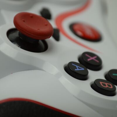 Ein weißer Gaming-Controller mit bunten Knöpfen als Nahaufnahme.
