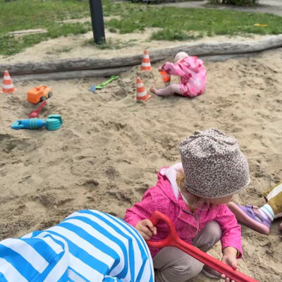 Vier Kinder spielen in einem großen Sandkasten