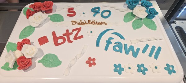 Bild vergr&ouml;&szlig;ern: Eine rechteckige Torte mit Blumenverzierungen und der Aufschrift 5 BTZ und 40 FAW.