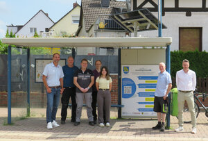 Bild vergr&ouml;&szlig;ern: Bauamtsleiter Marco Schulz, Michael Holzhauer und Christian Gericke vom Bauhof sowie Energiemanager Karsten Grünheier(2.v.r.) von der Gemeinde erhielten von Tobias Ellrott (Firma Hohrenk), Stefanie Otto(wissenschaftliche Mitarbeiterin) und Prof. Dr.-Ing. Andreas Ligocki von  der Ostfalia stehen in dem Bushaltestellenwartehaus. Das hat ein begrüntes Dach und ein Solarpanel.