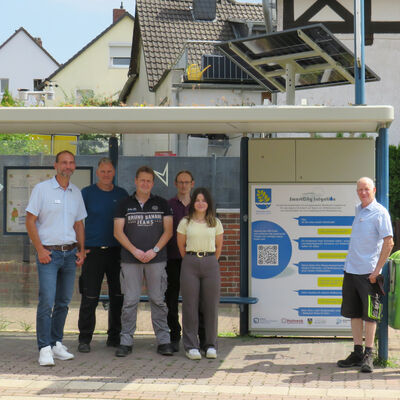 Bauamtsleiter Marco Schulz, Michael Holzhauer und Christian Gericke vom Bauhof sowie Energiemanager Karsten Grünheier(2.v.r.) von der Gemeinde erhielten von Tobias Ellrott (Firma Hohrenk), Stefanie Otto(wissenschaftliche Mitarbeiterin) und Prof. Dr.-Ing. Andreas Ligocki von  der Ostfalia stehen in dem Bushaltestellenwartehaus. Das hat ein begrüntes Dach und ein Solarpanel.