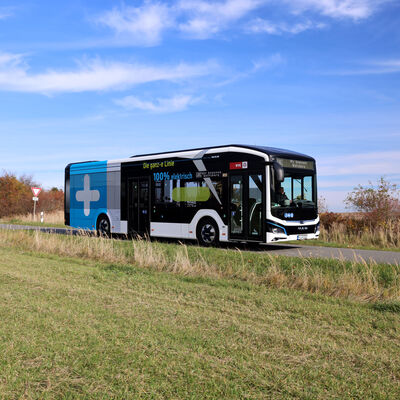 Auf einer Landstraße fährt ein Linienbus. 