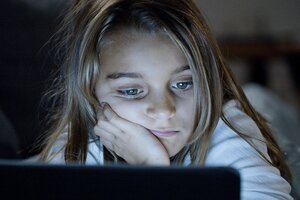 Bild vergr&ouml;&szlig;ern: Ein etwa sechsjähriges Mädchen schaut mit einem traurigen Gesichtsausdruck auf einen Computerbildschirm