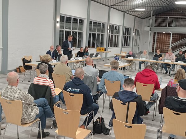 Im Vordergrund sieht man Zuschauende von hinten und hinten einen Teil des Rates.