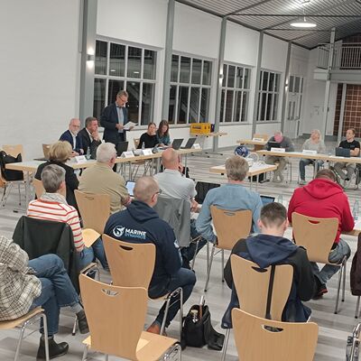 Im Vordergrund sieht man Zuschauende von hinten und hinten einen Teil des Rates.