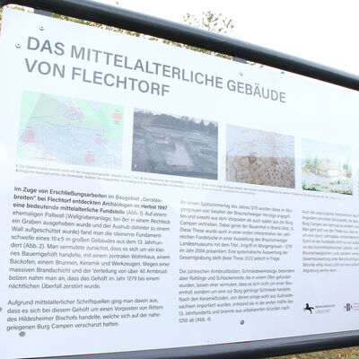 Bild vergr&ouml;&szlig;ern: Die Vorderseite der Infotafel mit der Überschrift "Das Mittelalterliche Gebäude von Flechtorf". Zu sehen sind vier Bilder und Zeichnungen sowie Text.