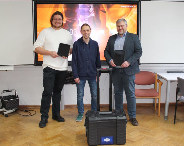 Bild vergr&ouml;&szlig;ern: Foto(© Gemeinde Lehre): Maximilian Hömme, komm. Rektor Grundschule Lehre, und Frank Lange, Rektor der Schunterschule Flechtorf, mit den neuen Tablets zusammen mit Chris Schulze, IT-Systemadministrator der Gemeinde Lehre, vor einem der Smartscreens.
