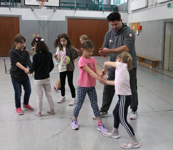 Bild vergr&ouml;&szlig;ern: Foto (© Gemeinde Lehre): Die Kinder üben  zusammen mit Trainer Milutin Susnica wie man sich durch die „Haifischflosse“ aus dem Griff eines Gegners befreit.