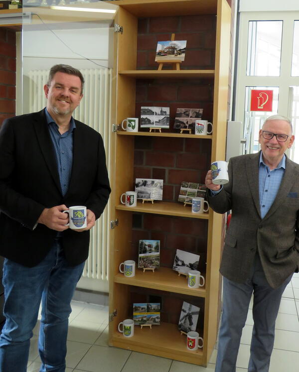 Bild vergr&ouml;&szlig;ern: Foto (© Gemeinde Lehre): Bürgermeister Andreas Busch (links) und Heimatpfleger Wilhelm Knigge vor der Vitrine im Obergeschoss des Rathauses.