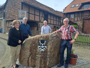 Bild vergr&ouml;&szlig;ern: Foto(Gemeinde Lehre): Ortsbürgermeisterin Kerstin Jäger, Steinmetz und Bildhauer Rainer Scheer, Andreas Rebel vom Heimatverein  und Ortsheimatpfleger Lothar Bremer bei der Einweihung von "Bruno".