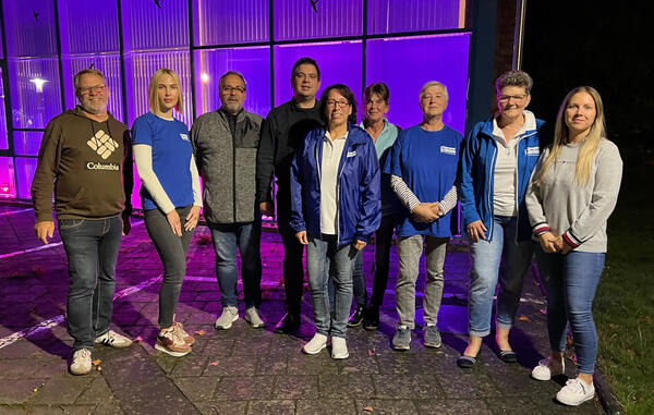 Bild vergr&ouml;&szlig;ern: Foto(Ralf Bayer): Die Gleichstellungsbeauftragte Lisa-Marie Westphal(1. V. rechts) gemeinsam mit der Gruppe Wolfsburg-Gifhorn von Plan International Deutschland und Gästen der Infoveranstaltung vor dem pink beleuchtenden Rathaus.