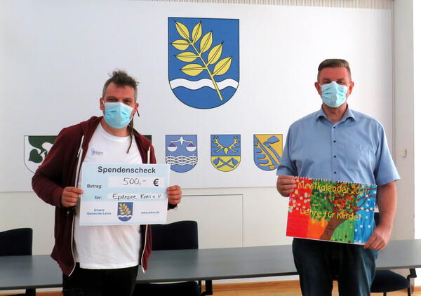 Bild vergr&ouml;&szlig;ern: Spende Kunstkalender 2021, Vorsitzender des Vereins Epilepsie Kids (links) und Gemeindebürgermeister Andreas Busch bei der Übergabe der Spende