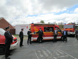 Bild vergr&ouml;&szlig;ern: Foto (© Gemeinde Lehre): Feierliche Schlüsselübergabe vor dem Feuerwehrgerätehaus der Ortfeuerwehr Lehre – (v. l.) Kreisbrandmeister Olaf Kapke, stellvertretender Ortsbrandmeister Maik Goerke, Ortsbrandmeister Jan Wehrstedt, Gemeindebrandmeister Simon Reb