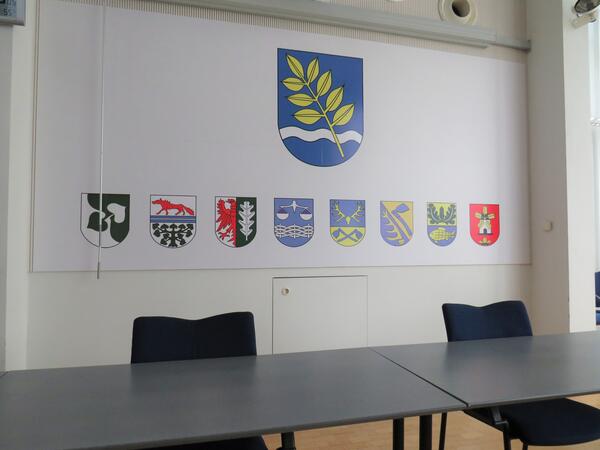 Bild vergr&ouml;&szlig;ern: Bild (Quelle: Gemeinde Lehre): Wappenwand im Ratssaal der Gemeinde Lehre. Zu sehen sind das Gemeindewappen und die acht Ortschaftswappen.